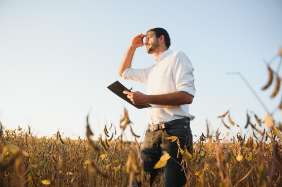 Homem no campo monitorando a lavoura através da digitalização no agronegócio brasileiro