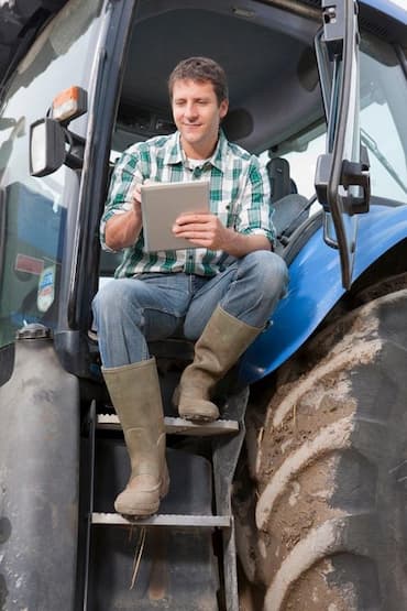 Produtor no seu maquinário utilizando ferramentas da agricultura digital