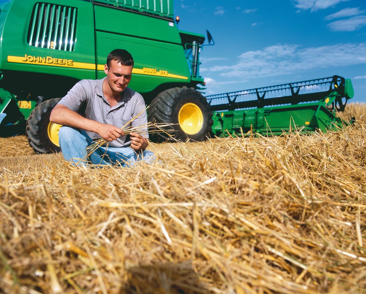 Produtor agrícola analisa palha sobre o solo